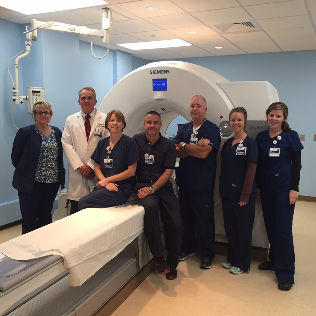 Greensboro team posing in front of an MRI machine